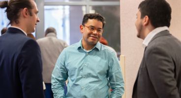 Dr. Caldera talking to two men in suits.