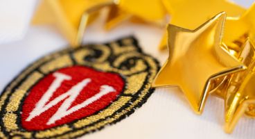 Star pins on a white doctor's coat with the UW crest