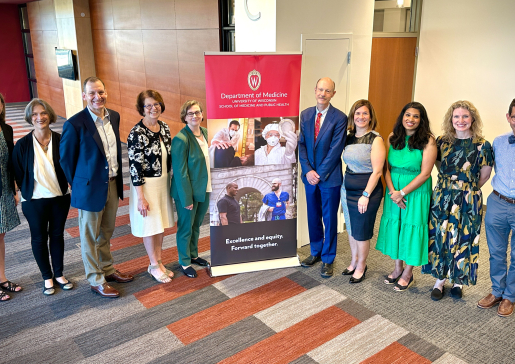 Department of Medicine faculty posing next to a Department of Medicine banner.