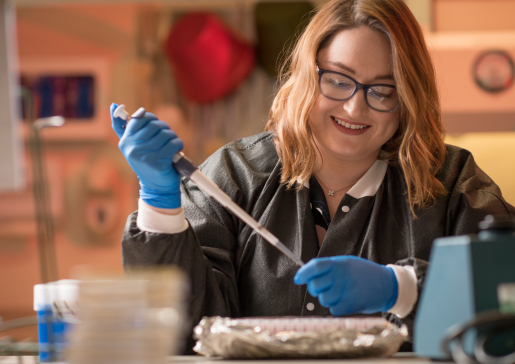 Infectious Disease researcher Ashley Kates using a pipette in the lab