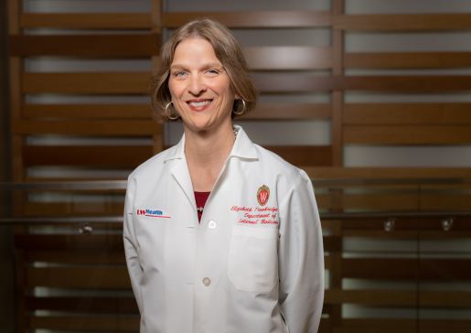 Betsy Trowbridge, MD, in her white coat.