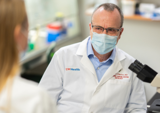 Closeup of Dr. Mark Albertini wearing a mask talking to a colleauge