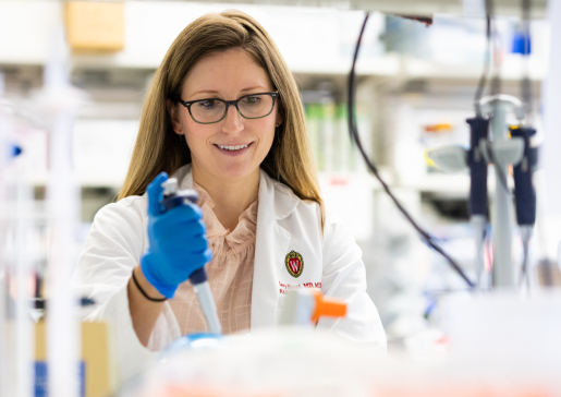 photo of Dr. Hilary Faust holding a pipette in her lab