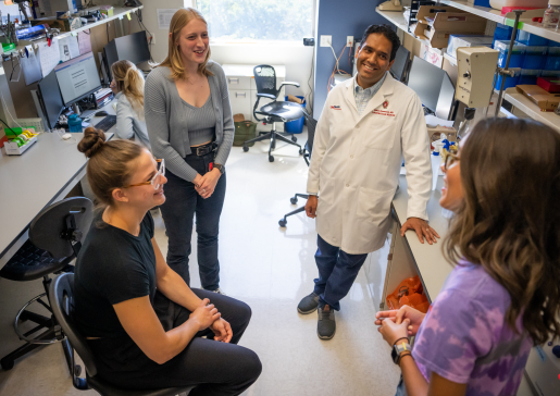 photo of Dr. Mohan Ramratnan talking with research team