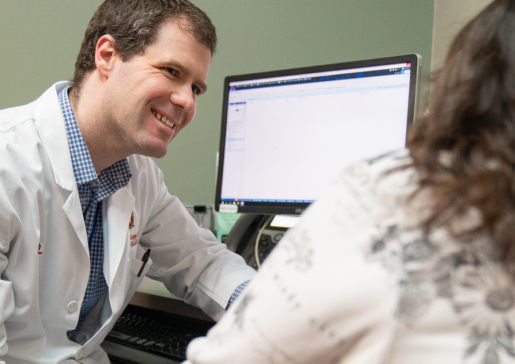 Electrophysiology cardiologist Dr. Ryan Kipp talks with a patient in the clinic
