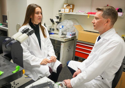 Dr. Alexey Glukhov and female lab staff member facing each other and talking in the lab