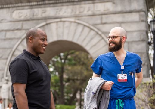 Two University of Wisconsin internal medicine talk in front of the Camp Randall arch