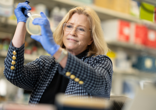 Closeup of Dr. Shannon Kenney holding a pipette in the lab