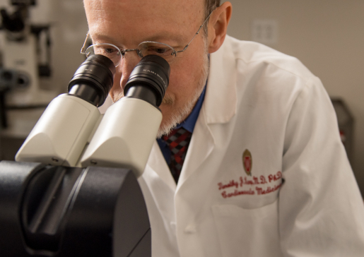 Closeup of Dr. Timothy Kamp at the microscope