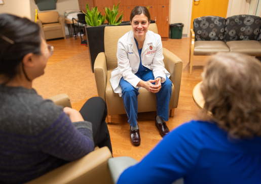 Dr. Jackie Kruser talking with colleagues in a hospital seating area
