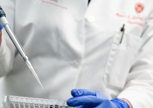 Closeup of Dr. Miriam Shelef in white coat working in the lab