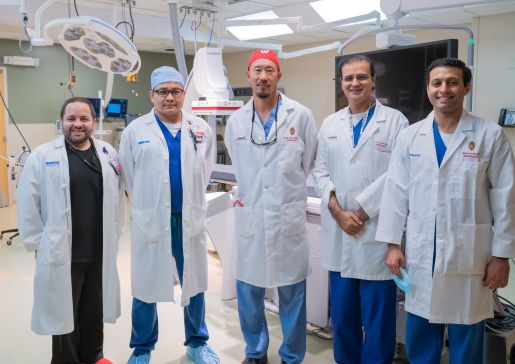 Five members of the interventional nephrology team standing side-by-side in a procedure room