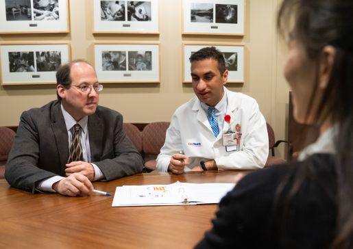 Drs. Brad Astor and Sandesh Parajuli talk at a conference room table