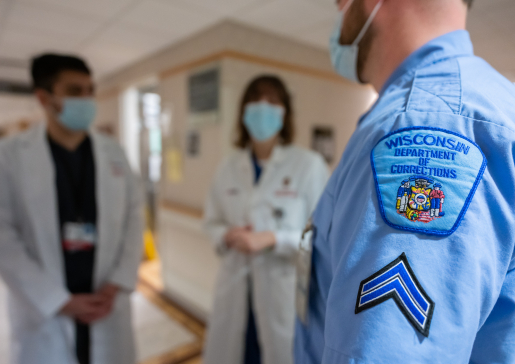 Dr. Farah Kaiksow and learner with corrections officer in foreground