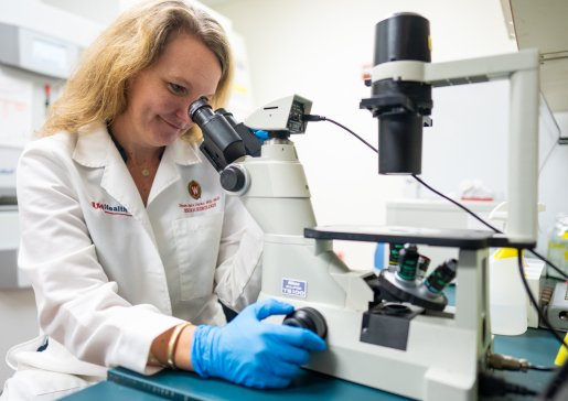 Dr. Dawn Davis looking through a microscope in her lab.