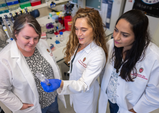 Drs. Lee Eckhardt and Louise Reilly look at a specimen together in the lab