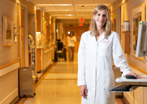 Dr. Ann Sheehy wearing a white coat standing in the hallway of University Hospital