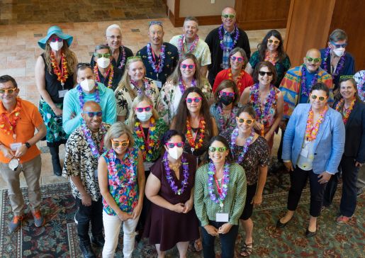 Group photo of department faculty and staff wearing Hawaiian shirts and leis at a leadership retreat