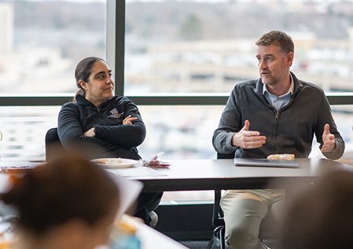 Drs. Marina Sharifi and Josh Lang talking with PSTP trainees in a conference room