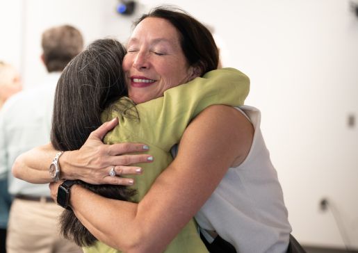 Dr. Lisa Grant hugs a colleague at a Department of Medicine promotions event