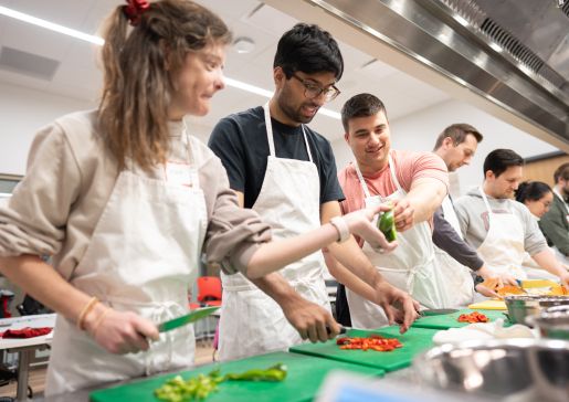 Photo of PG-1s Kara Donovan, MD; Yasgh Hegde, MD; and Tyler Rubeor, MD, trying their hand at vegetable preparation in the Bakke Recreation Center.