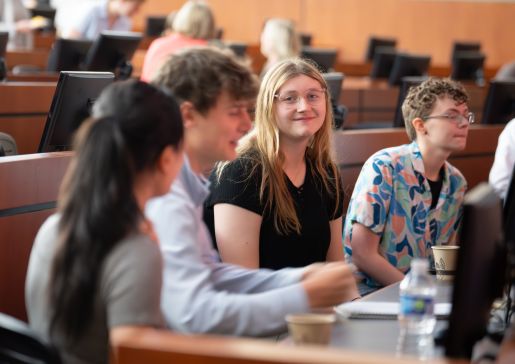 People sit in rows of a lecture hall