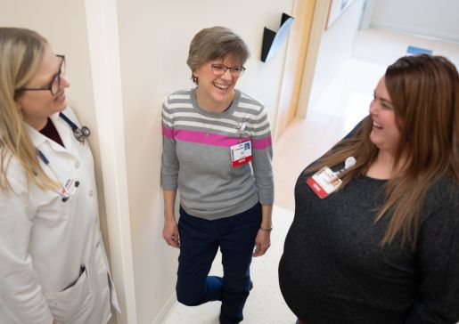 Dr. Christie Bartels and two nurses talking together in the hallway of the rheumatology clinic