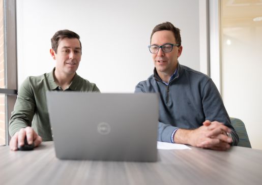 Andy Holt and Dr. Ed Vasilevskis sitting at a conference room table looking at a laptop computer screen