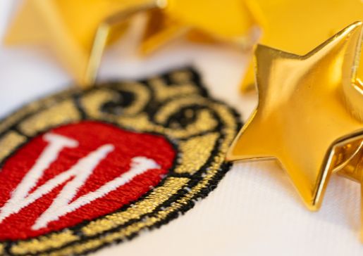 Star pins on a white doctor's coat with the UW crest