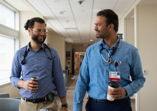 Two physicians walking down a hallway in a hospital.