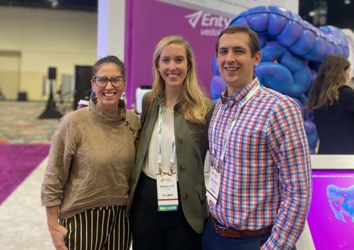 Three people standing at a conference