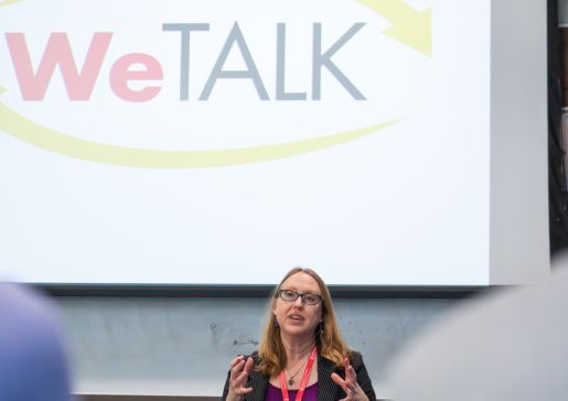 Dr. Amy Zelenski talking in front of a screen with a WeTALK logo slide