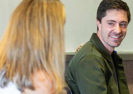 Two participants facing each other and speaking during a workshop