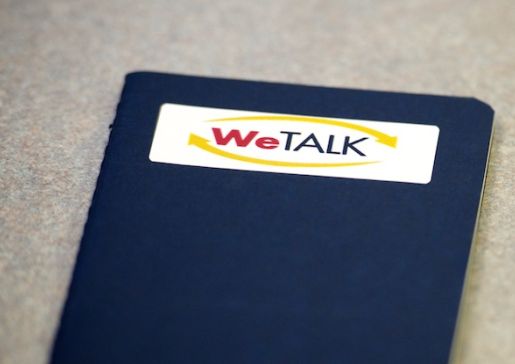 A notebook with a WeTALK logo sticker